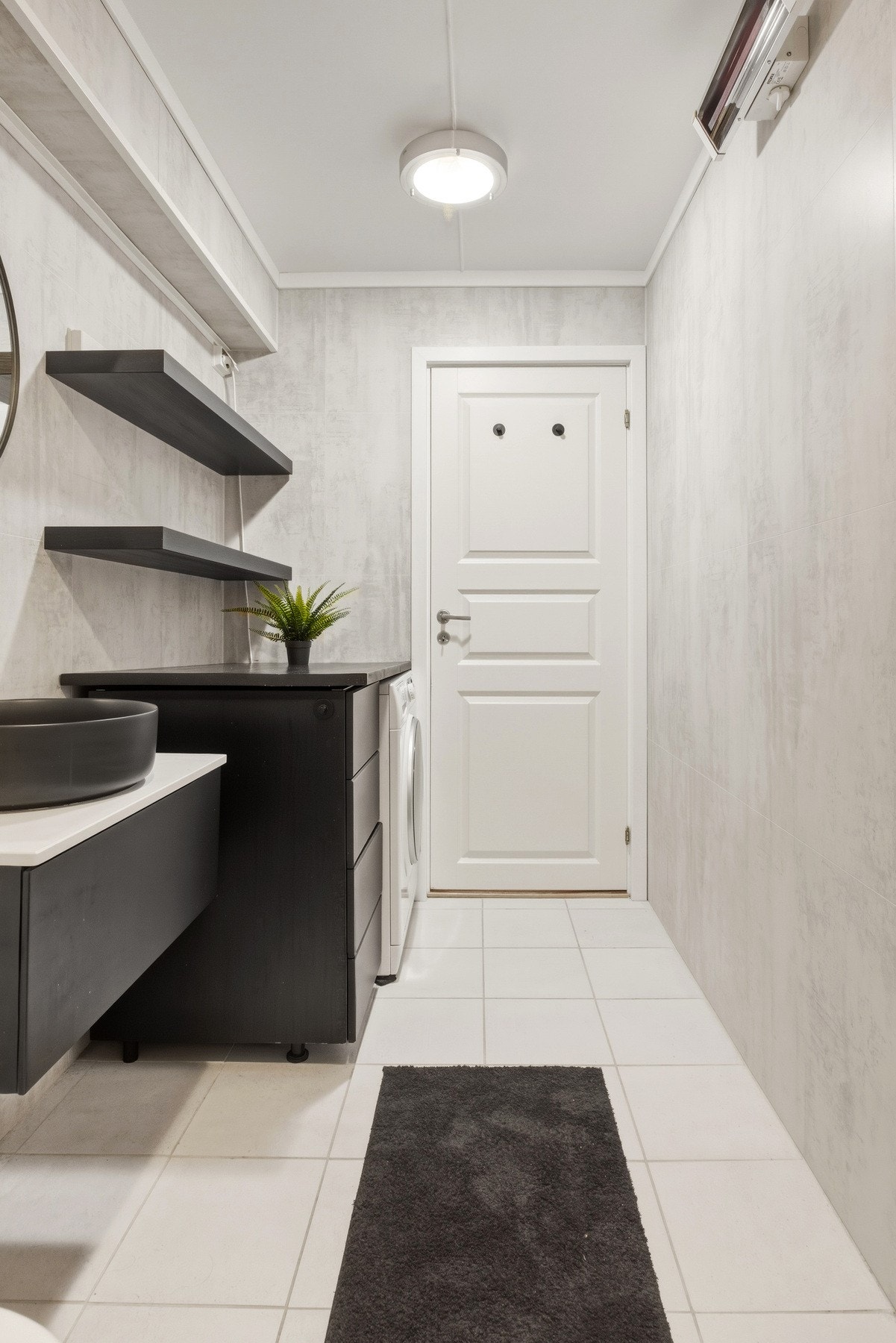 Badet har regnfallsdusj og innredning i sort design, noe som gir en elegant helhet til stilen i øvrige rom. Galleribilde