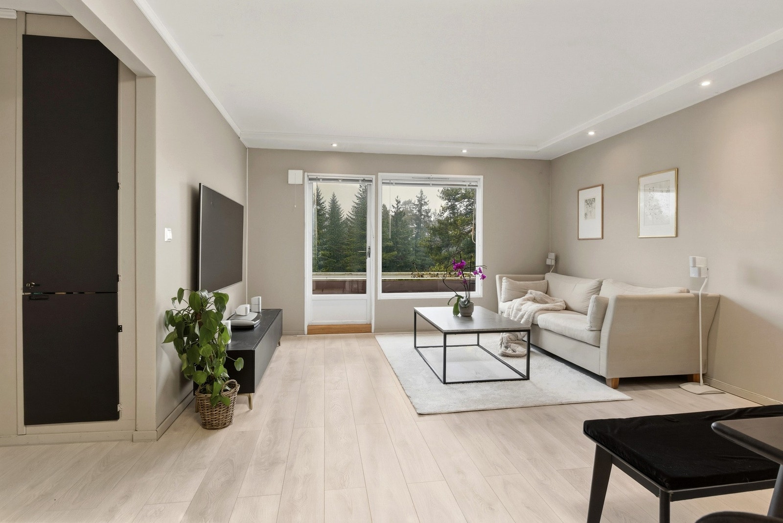 Stuen har enstavs laminatgulv, beige veggflater og downlights langs tre sider av himlingen. Galleribilde