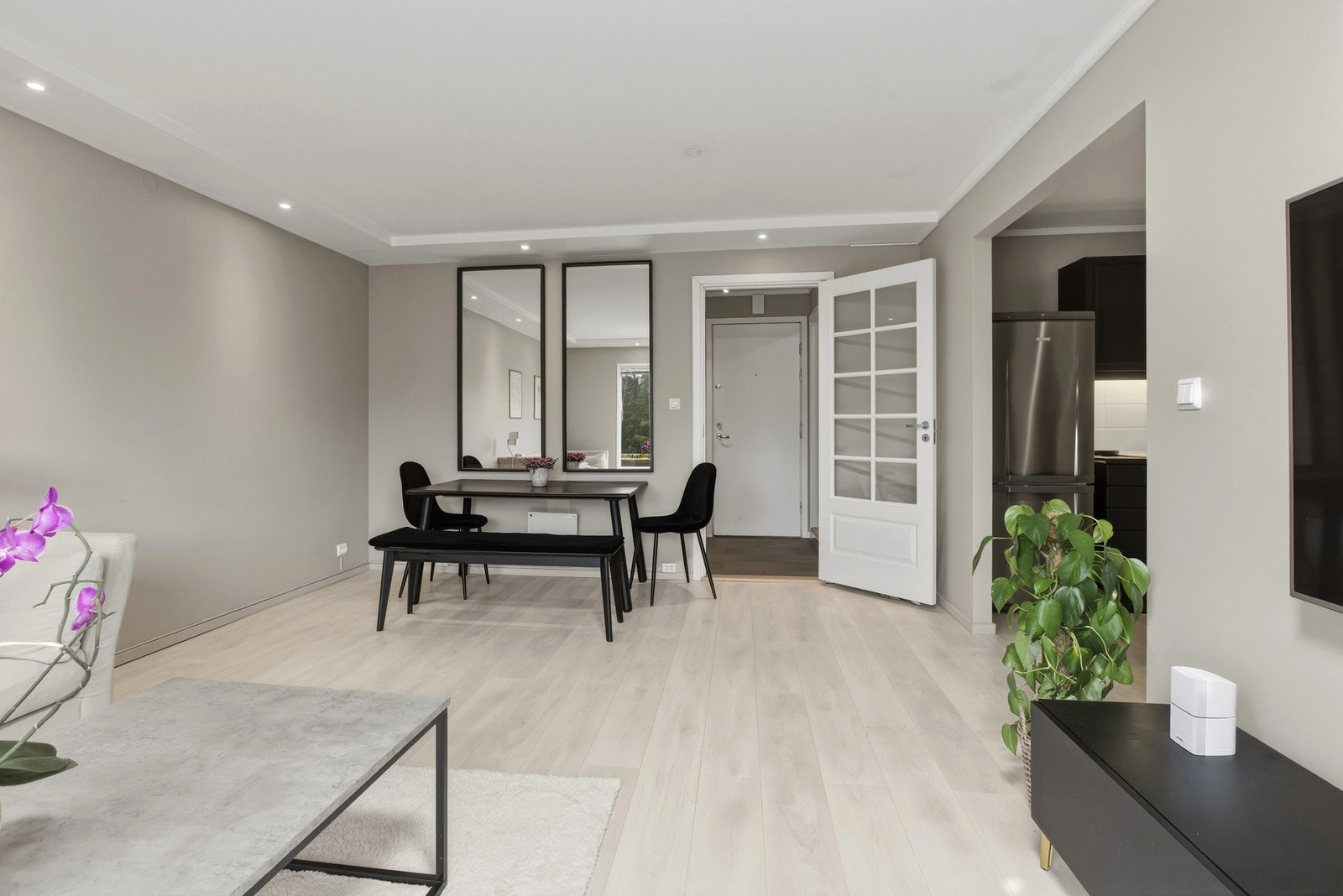 Fra entreen fører en dør med glassfelt inn til en luftig og lys stue med gode vindusflater og grønt utsyn. Galleribilde