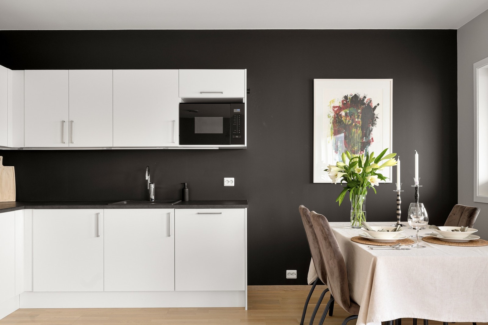 Innredningen fra Norema har hvite, glatte fronter og grå laminatbenkeplate med nedfelt kum i stål. Galleribilde