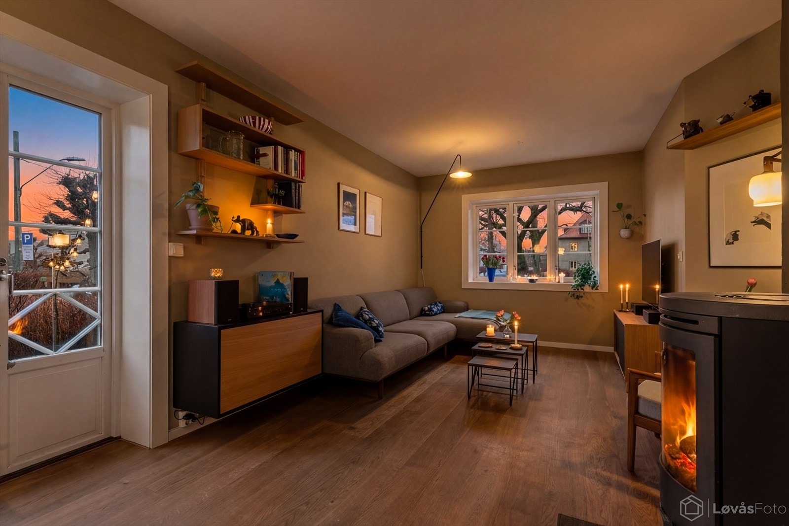 Når kvelden faller på, skaper vedovnen og det varme lyset fra lampene en lun og stemningsfull atmosfære i stuen. Galleribilde