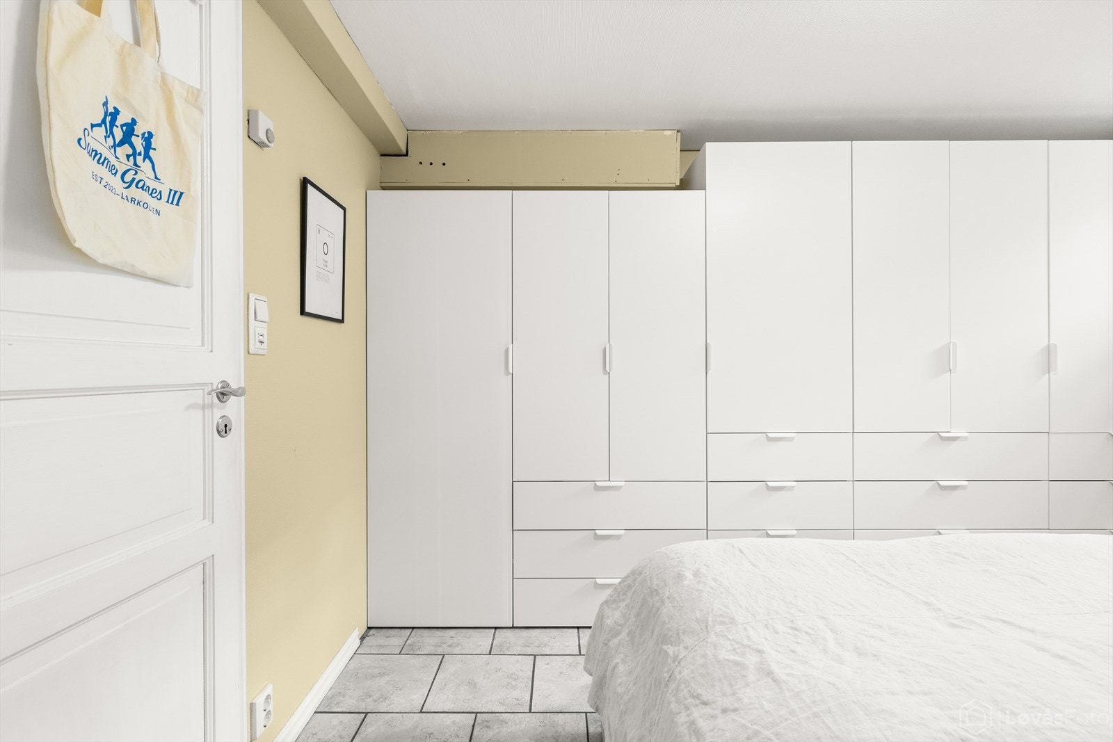 Langs den ene veggen er det etablert en romslig garderobeløsning med både skap og skuffer, noe som gir svært gode oppbevaringsmuligheter og bidrar til en praktisk og ryddig løsning. Galleribilde