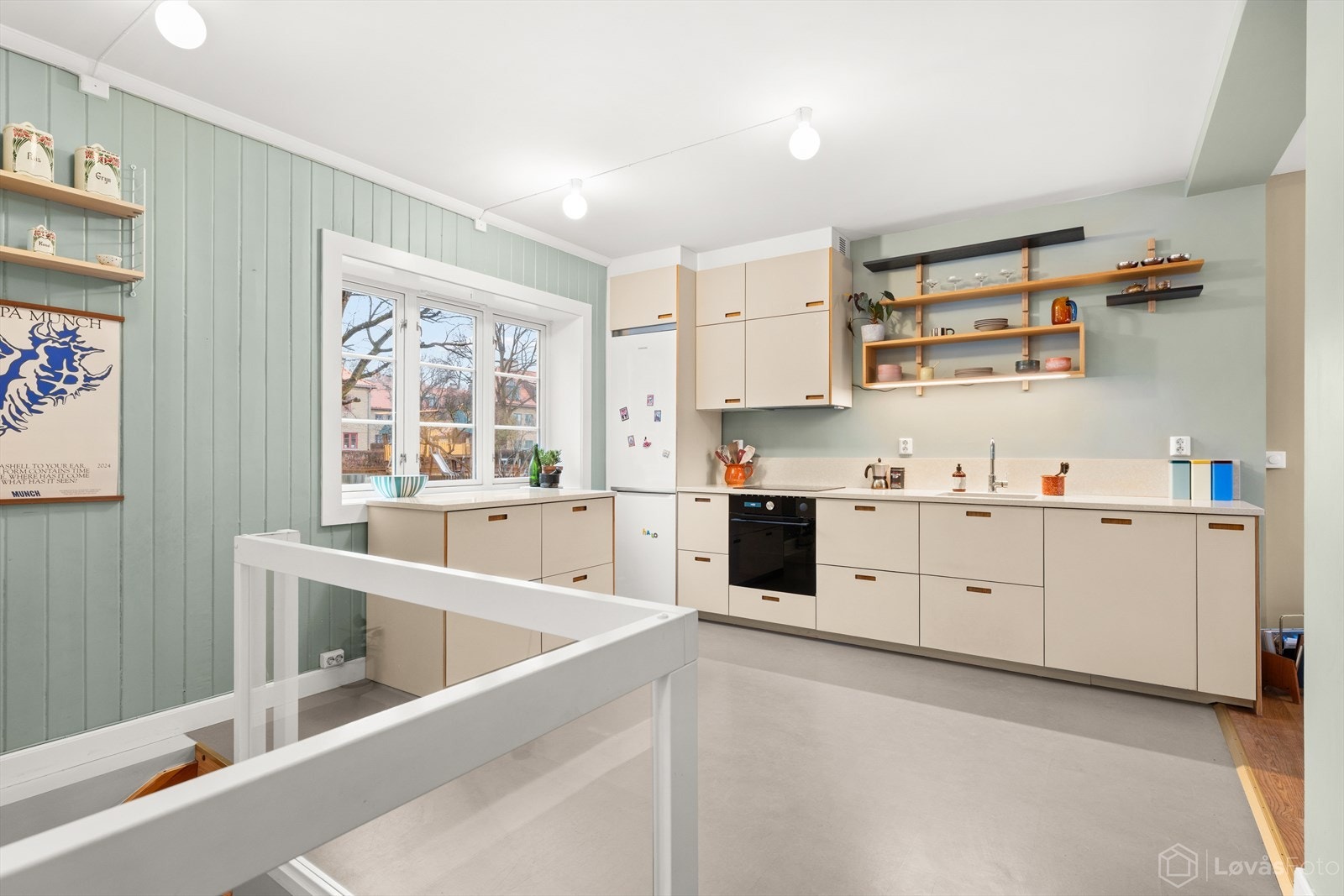 Kjøkkenet har en praktisk utforming med god plass til både matlaging og oppbevaring, med skuffer, skap og åpne hyller som gir enkel tilgang til kjøkkenutstyr. Galleribilde