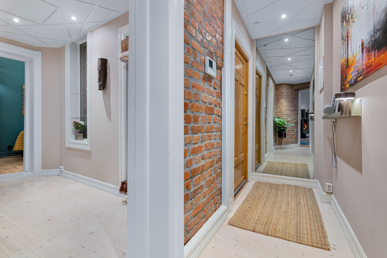 Gangen har lyse tregulv, glatte malte overflater kombinert med synlig teglstein og flott himling med innfelte downlights. Galleribilde