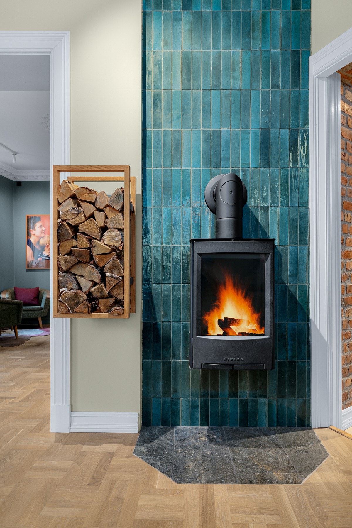 Som et flott blikkfang i stuen er det en vegghengt vedovn fra 2019 som både gir god varme og bidrar til ekstra hygge. Veggen bak ovnen er dekorert med lekre fliser. Galleribilde