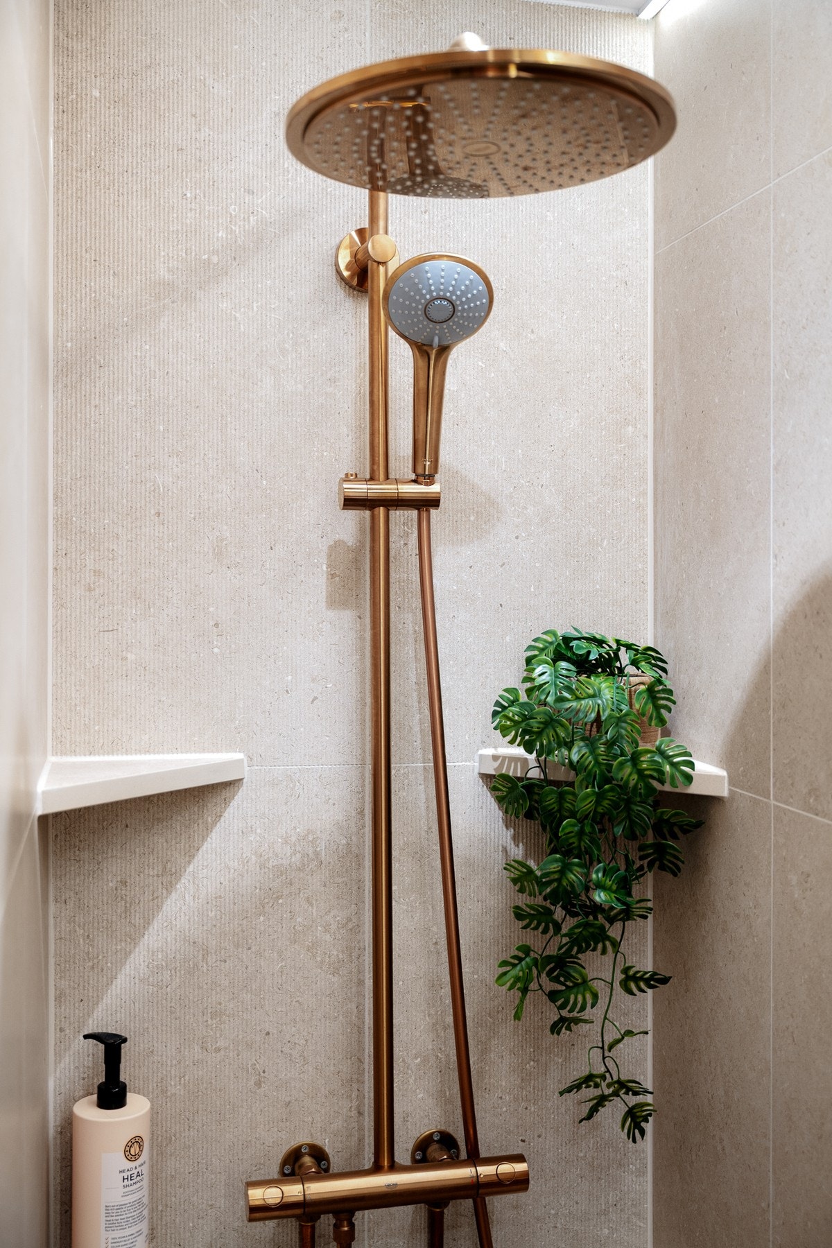 Dusjnisje med hyller og vegghengt armatur med både hånd- og regnfallsdusj. Galleribilde