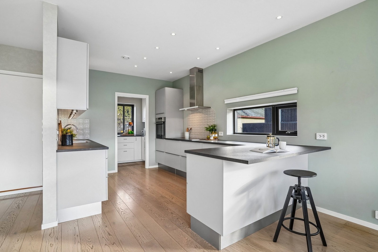 Kjøkkenet har en funksjonelt og innbydende innredning fra HTH med lyse glatte fronter og laminat benkeplate. Galleribilde