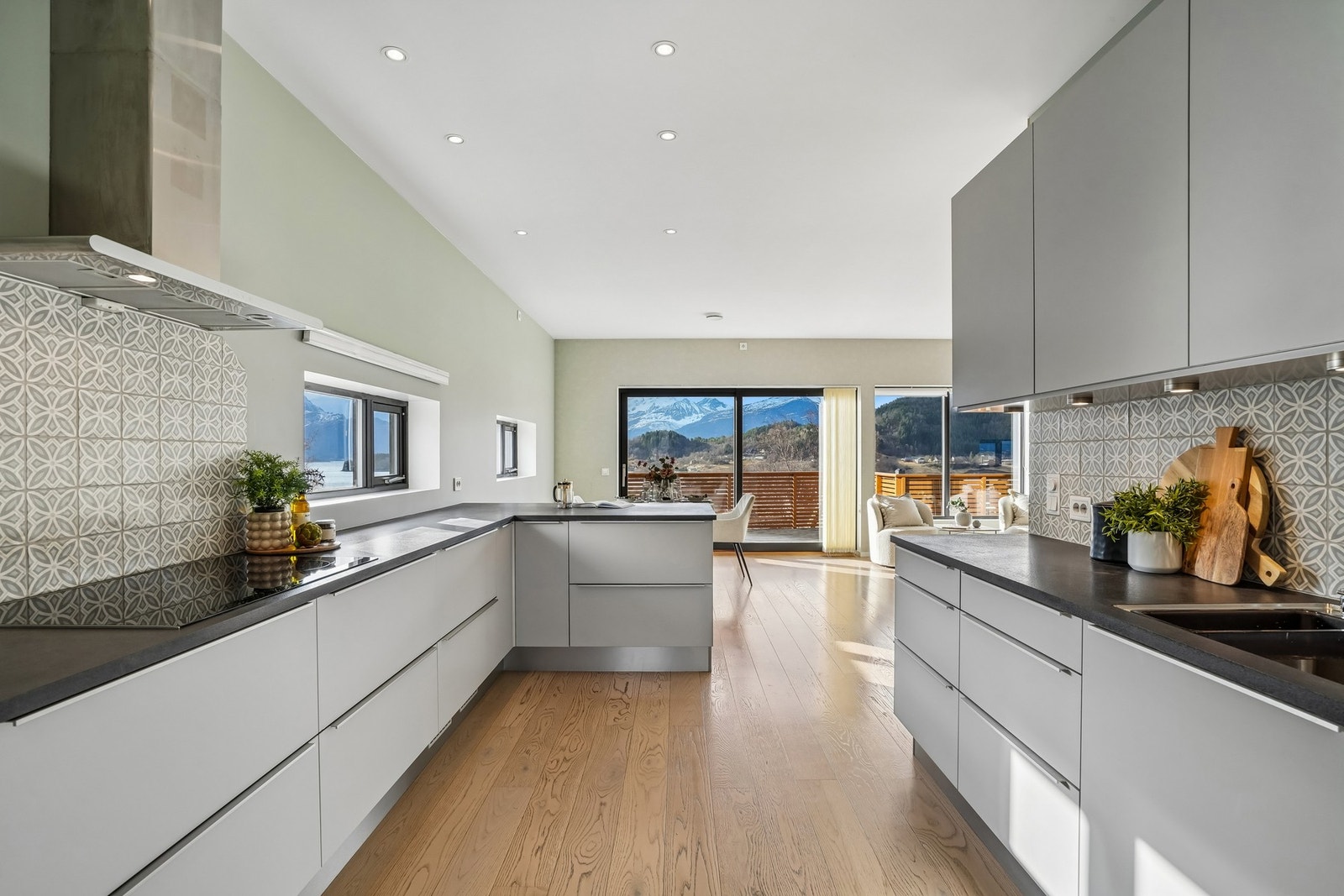 Moderne fliser på vegg over benkeplate, spotter under overskap og godt med skap- og skuffeplass. Galleribilde