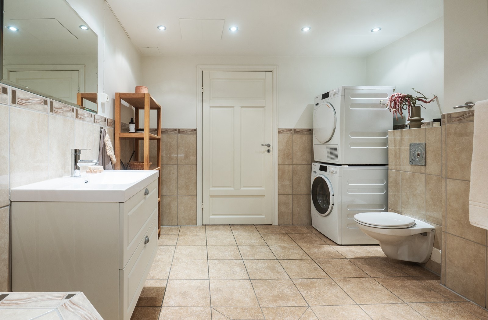 Badet har varmekabler i gulv og opplegg for vaskemaskin og tørketrommel. Galleribilde