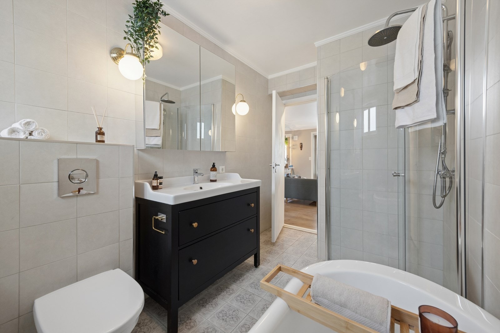 Badet er utstyrt med vegghengt toalett, servantinnredning og dusjvegger i glass. Galleribilde