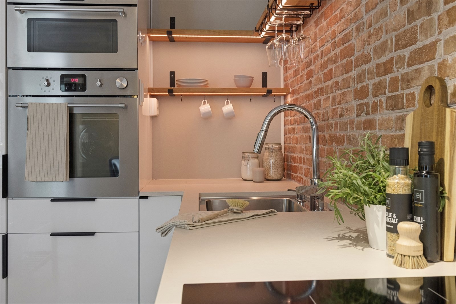 Moderne kjøkkenløsninger med god belysning over arbeidsbenken. Galleribilde