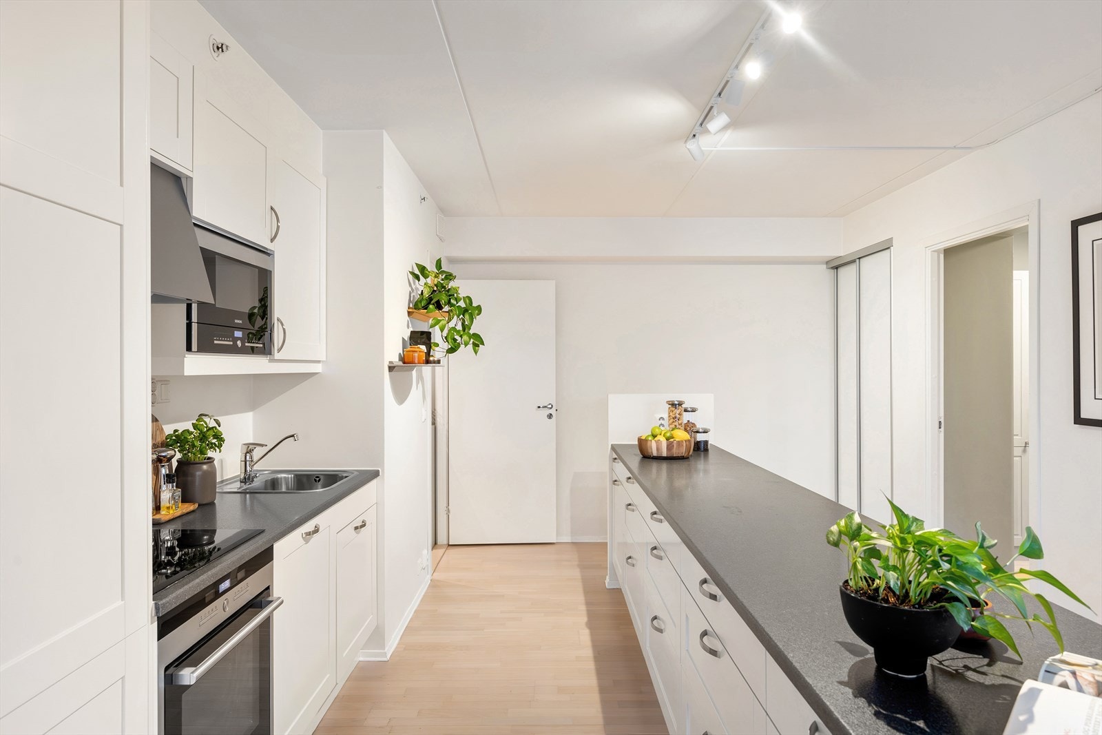 Innredningen består av både over- og underskap som gir gode oppbevaringsmuligheter. Det er montert belysning under overskapene. Kjøkkeninnredningen har hvite, profilerte fronter som gir et tidløst uttrykk, kombinert med laminat benkeplate. Galleribilde