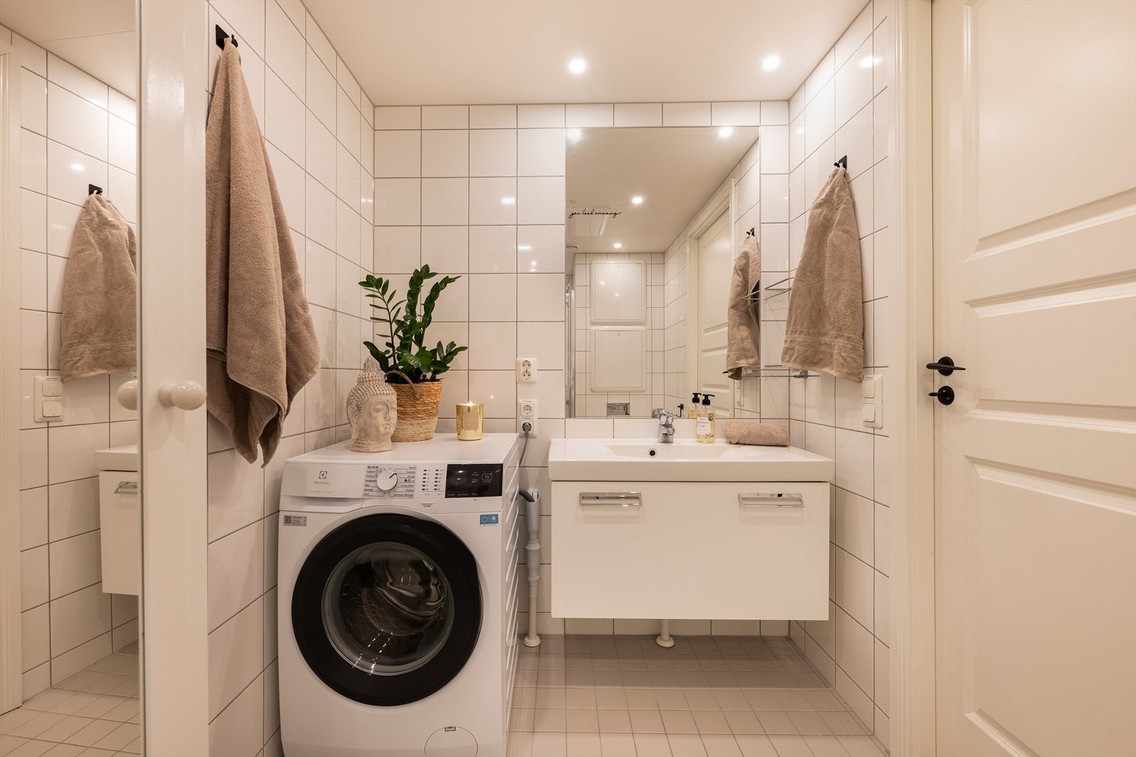 Badet er innredet med helservant på skuffeseksjon, vegghengt toalett, dusjnisje og opplegg for vaskemaskin. Galleribilde