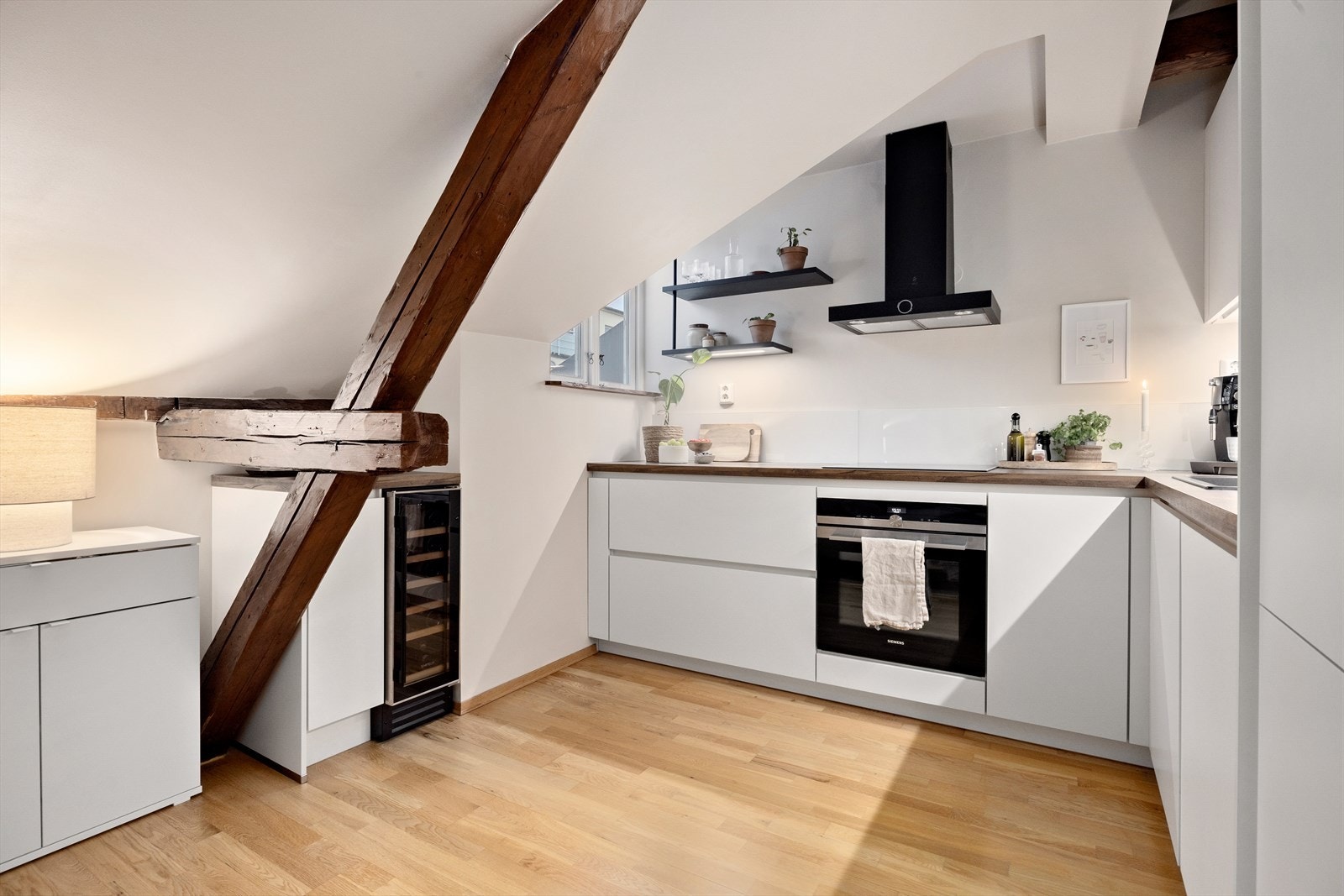 Lys og stilren KEO kjøkkeninnredning fra 2024 med glatte fronter og laminat benkeplate med nedfelt kum i plastkompositt. Galleribilde