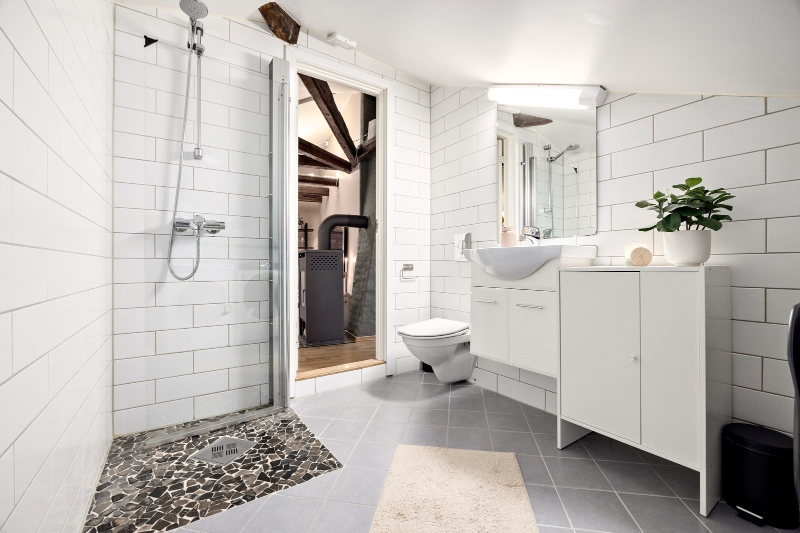 Videre er det dusj med innfellbare dører i herdet glass, servant og veggfestet klosett med innebygget sisterne. Galleribilde