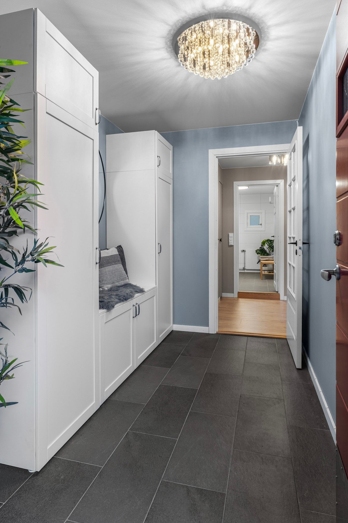 Stor flislagt entré med praktisk garderobeløsning Galleribilde