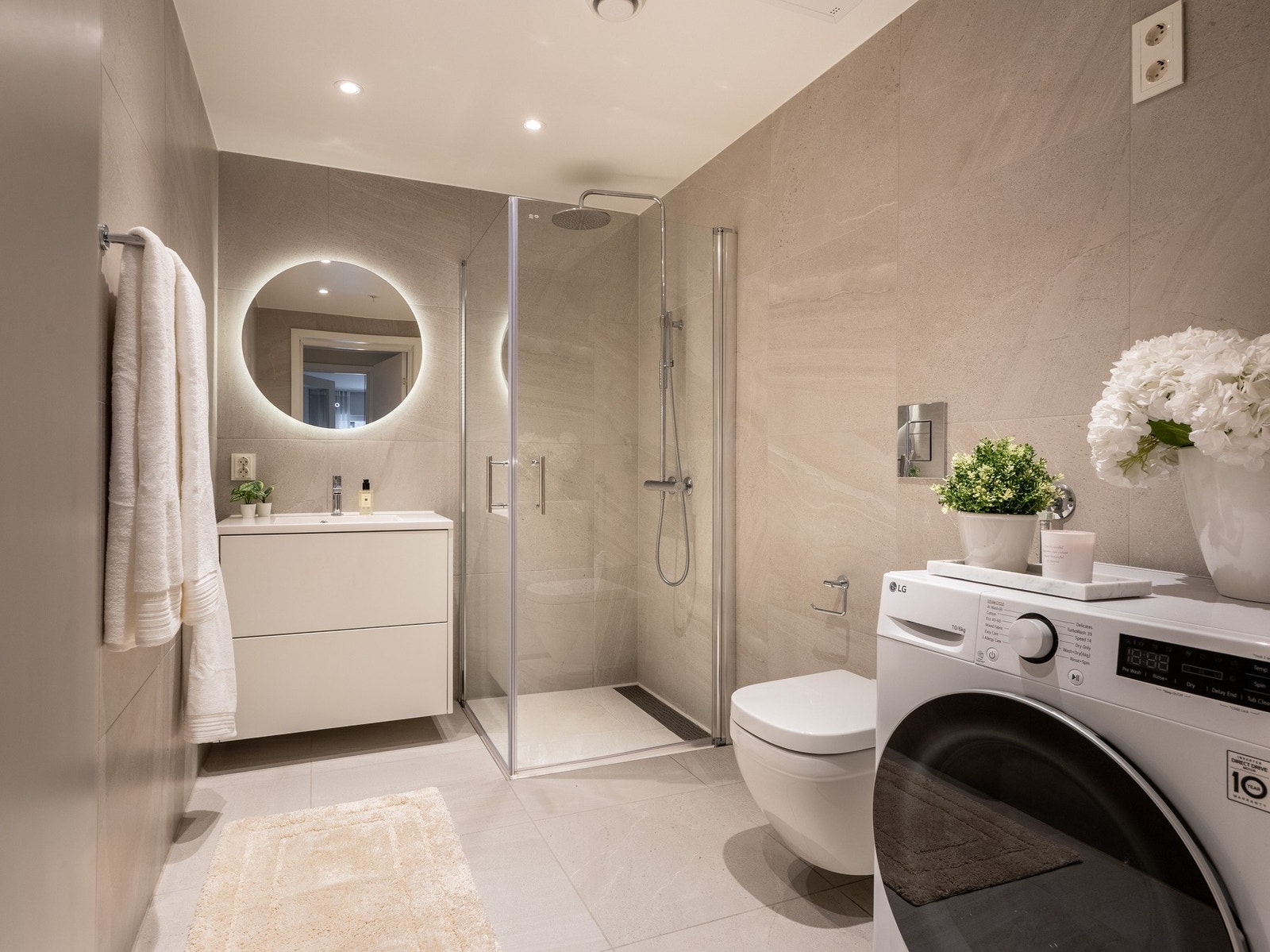 Lunt og romslig baderom fra 2024 med opplegg for vaskemaskin. Galleribilde