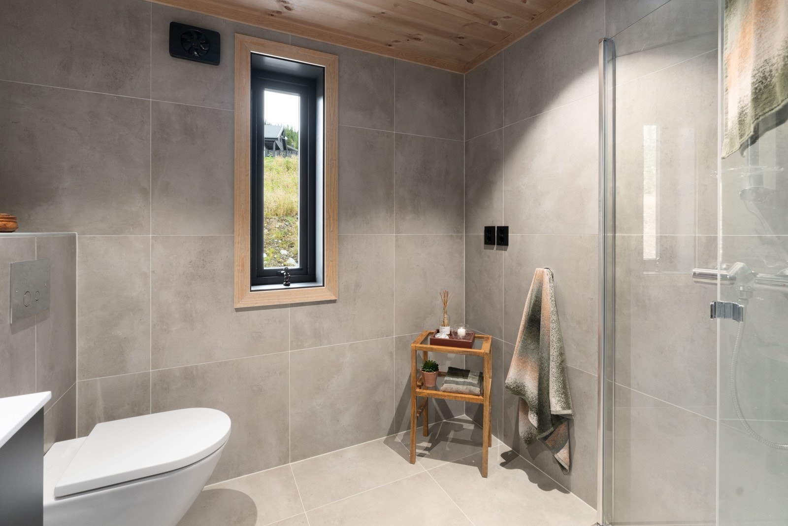 Det ene badet har 80cm sort innredning med 2 skuffer og hvit heldekkende servant, samt 1-greps blandebatteri og rundt speil på veggen. Vegghengt wc, rette dusjdører i glass ved dusj og dusjbatteri med garnityr og håndholdt dusj. Galleribilde