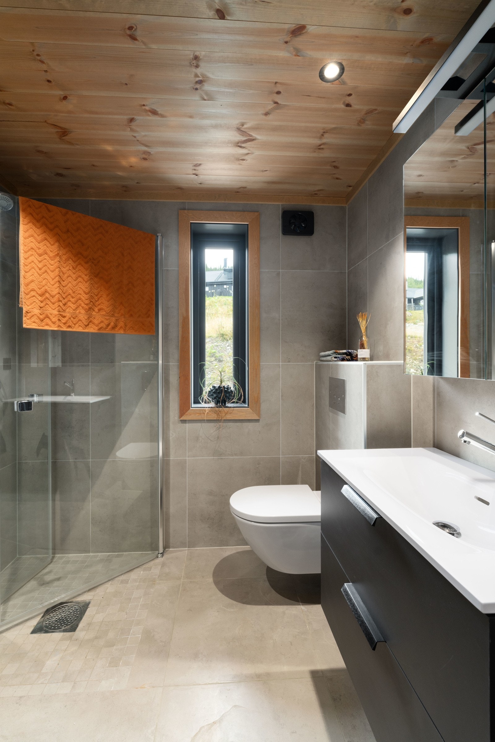 Det andre badet har 80cm sort innredning med 2 skuffer og hvit heldekkende servant, samt 1-greps blandebatteri og speilskap med belysning på toppen. Galleribilde