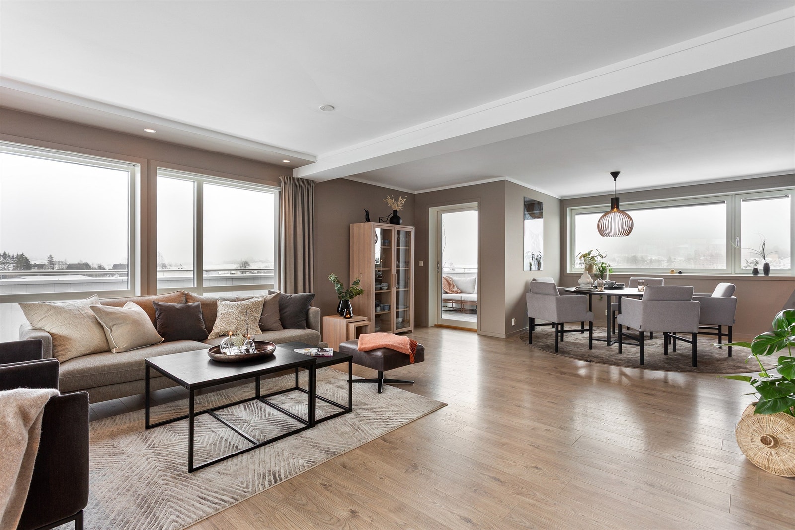 Romslig og lekker stue med store vindusflater, fra tre sider, som gir mye naturlig lys Galleribilde