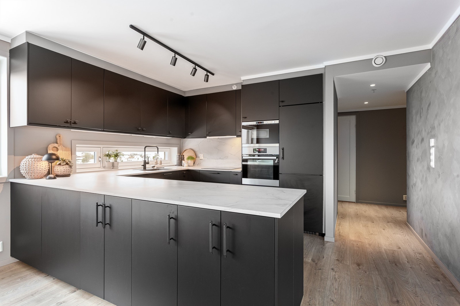 Pent kjøkken med IKEA innredning med glatte fronter. Benkeplate med laminert overflate og kjøkkenvask og kum. Galleribilde