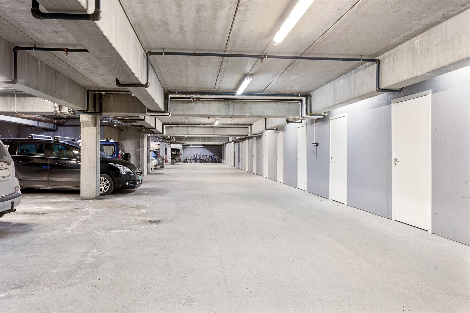 En parkeringsplass i felles garasjeanlegg. Det er montert elbillader på parkeringsplassen. Det følger med en bod rett ved p-plassen. Galleribilde