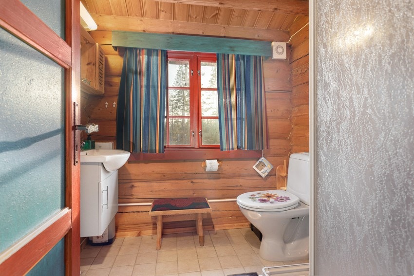 Bad innredet med servant på innredning, dusjkabinett og toalett. Galleribilde