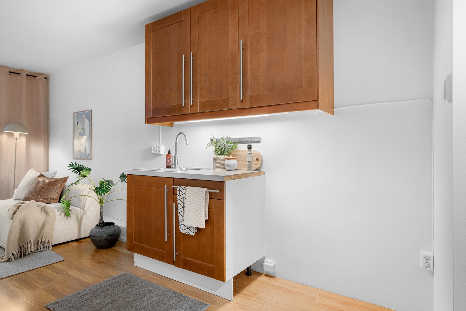 Innredningen har profilerte fronter, laminert benkeplate med nedfelt oppvaskkum og belysning under overskapene. Galleribilde