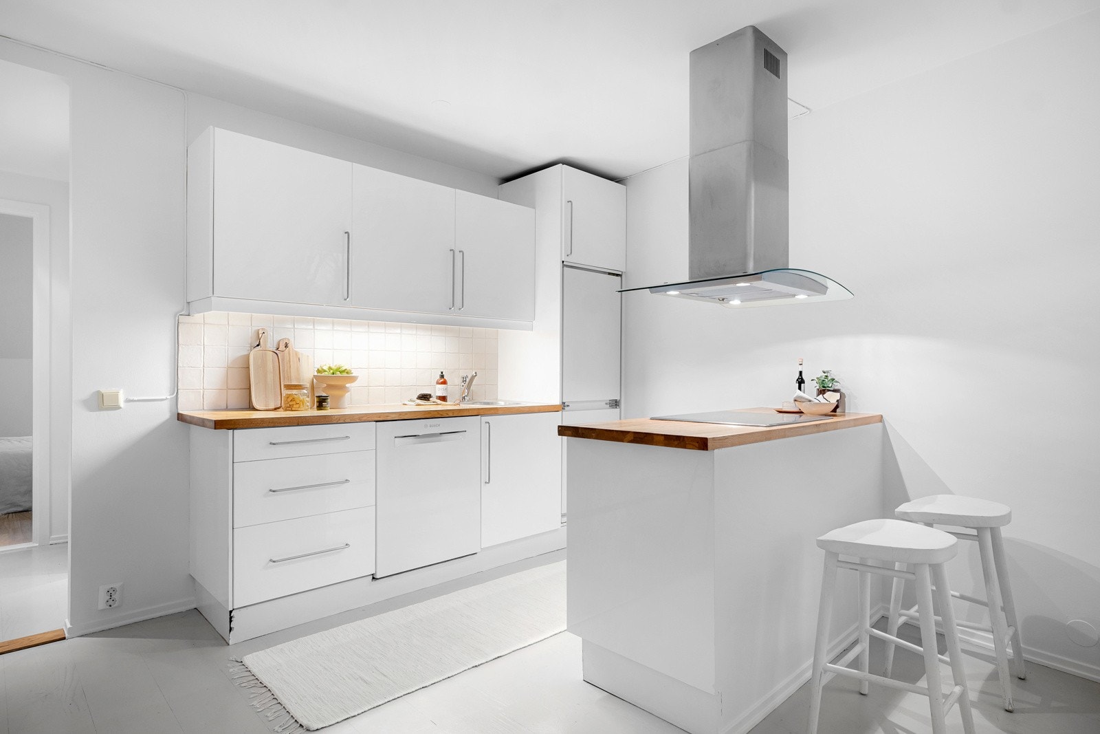 Lys og tidløs kjøkkeninnredning med en praktisk utforming som gir god skap- og benkeplass. Galleribilde