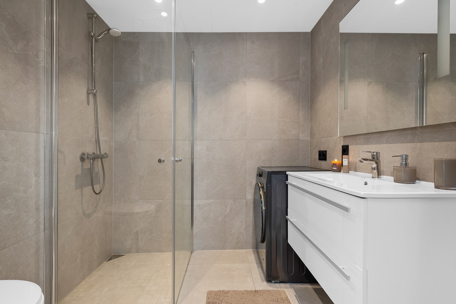 Leiligheten har et moderne og tiltalende baderom på 4,5 kvm, flislagt og med behagelige varmekabler i gulvet. Galleribilde