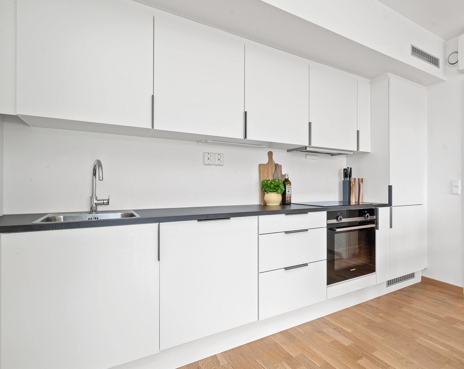 Kjøkkenet er levert av kvalitetsprodusenten HTH og har glatte fronter samt benkeplate i laminat. Innredningen har integrerte hvitevarer som platetopp, stekeovn, oppvaskmaskin og kjøleskap med frysedel. Galleribilde