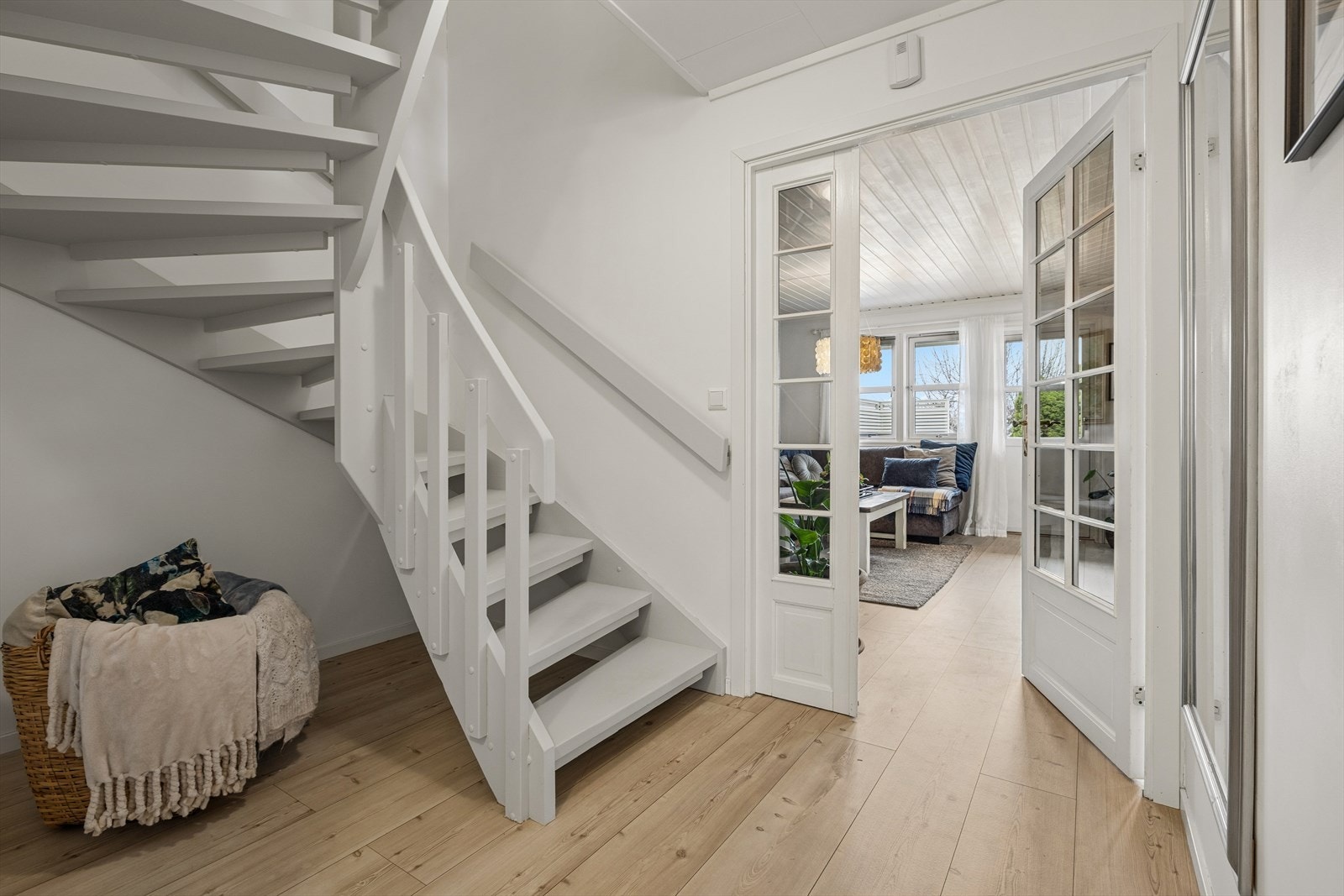 Gang mellom stuen og kjøkken med lysmalt trapp som tar deg til boligens 2.etasje. Galleribilde