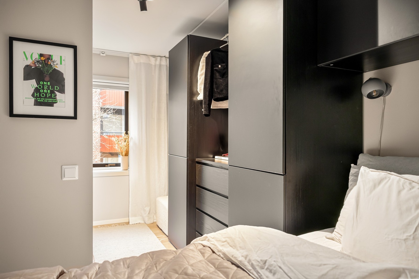 Rommet er innredet med en praktisk garderobeløsning som rammer inn sengen, med skap på sidene og overskap over sengen. Galleribilde