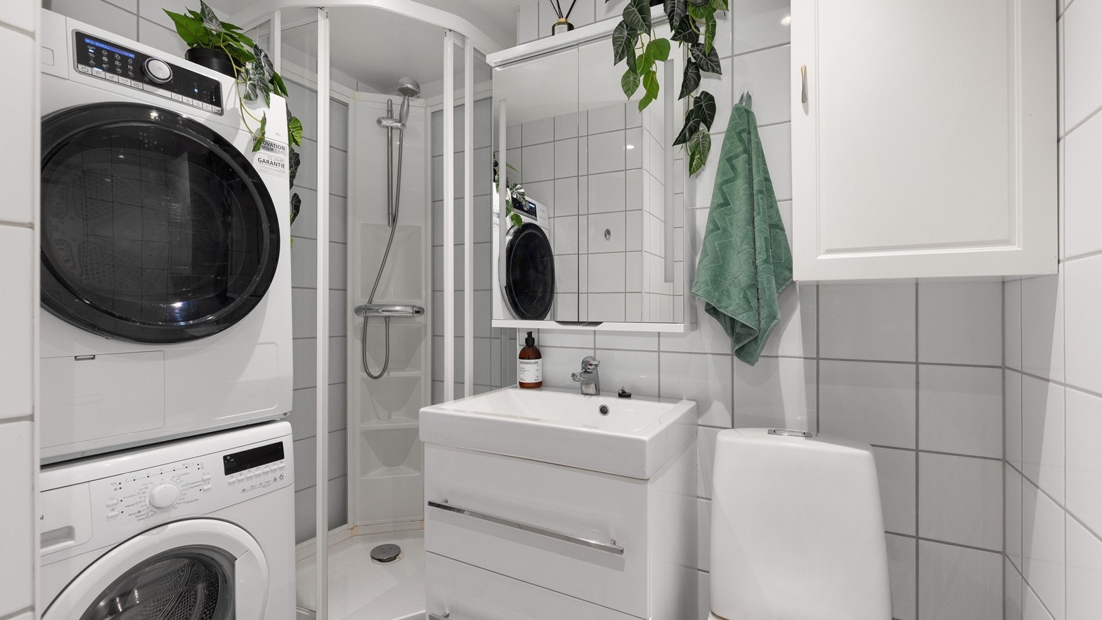 Lyst, flislagt bad med opplegg for vaskemaskin og tørketrommel Galleribilde