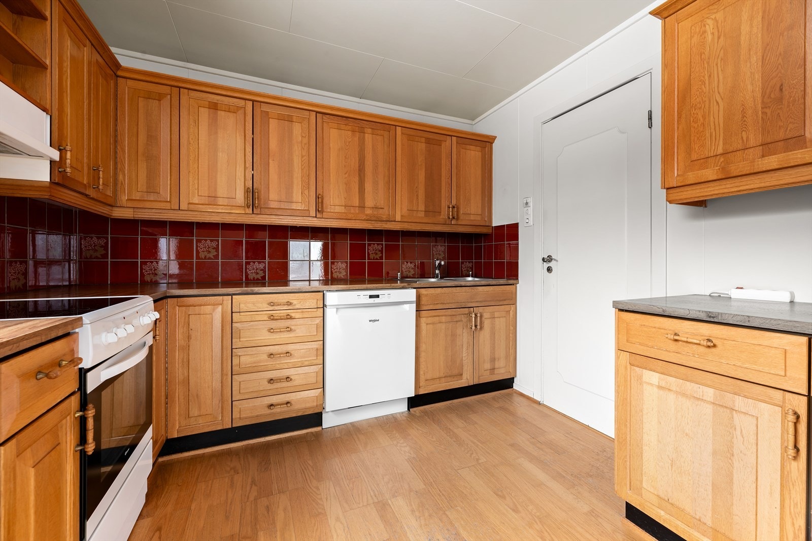 Kjøkken med Nygård kjøkkeninnredning i eik fra ca. 1985. Komfyr, oppvaskmaskin og kjøleskap medfølger. Praktisk med dør direkte fra kjøkkenet til vaskerom, Galleribilde