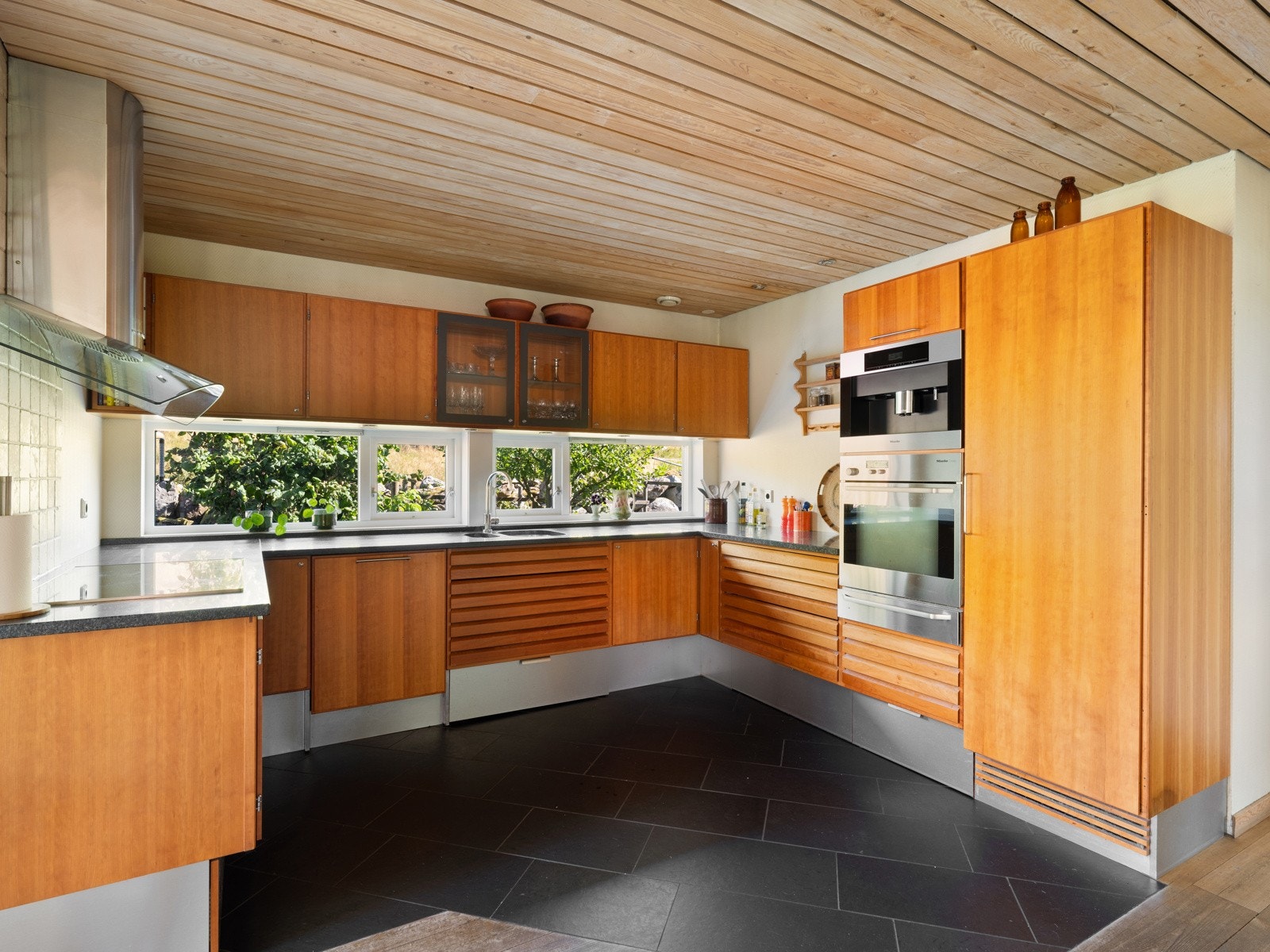 Kjøkkenet har slette fronter som gir et minimalistisk og tidløst uttrykk. Benkeplaten er i stein. Galleribilde