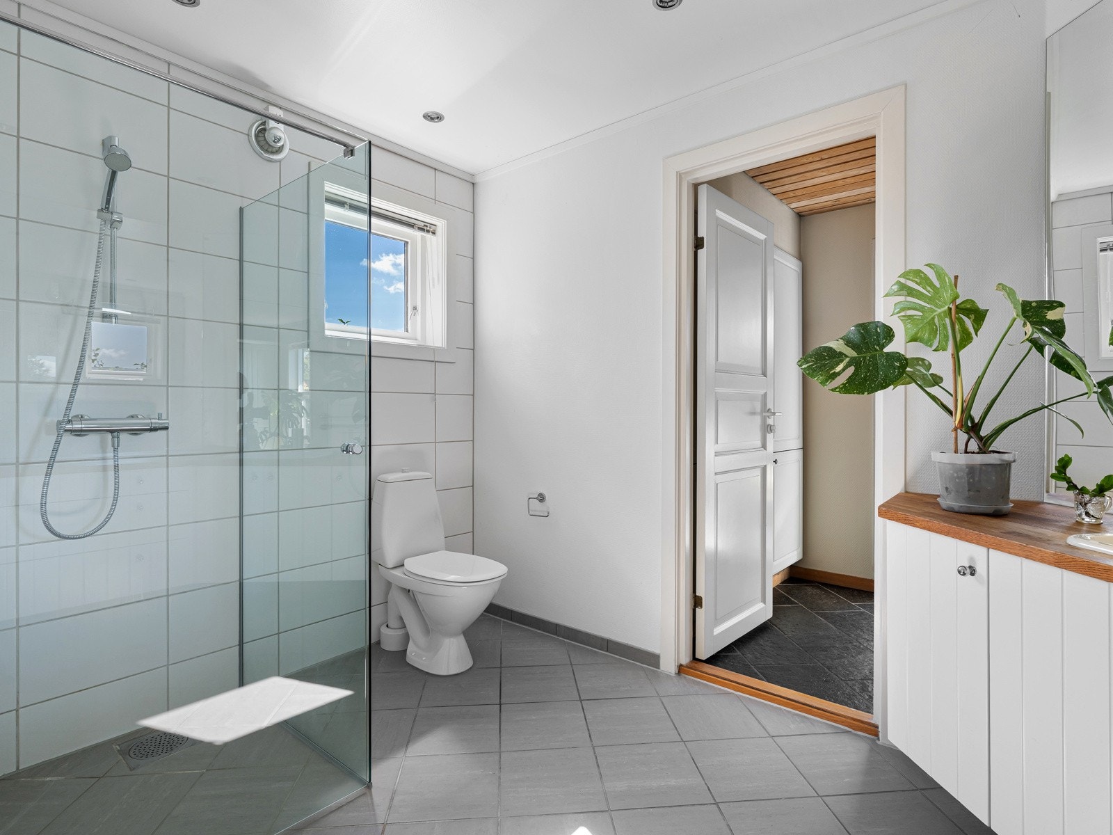 Badet i 1. etasje har fliser på gulv og deler av vegg. Resterende vegger har strietapet. Galleribilde