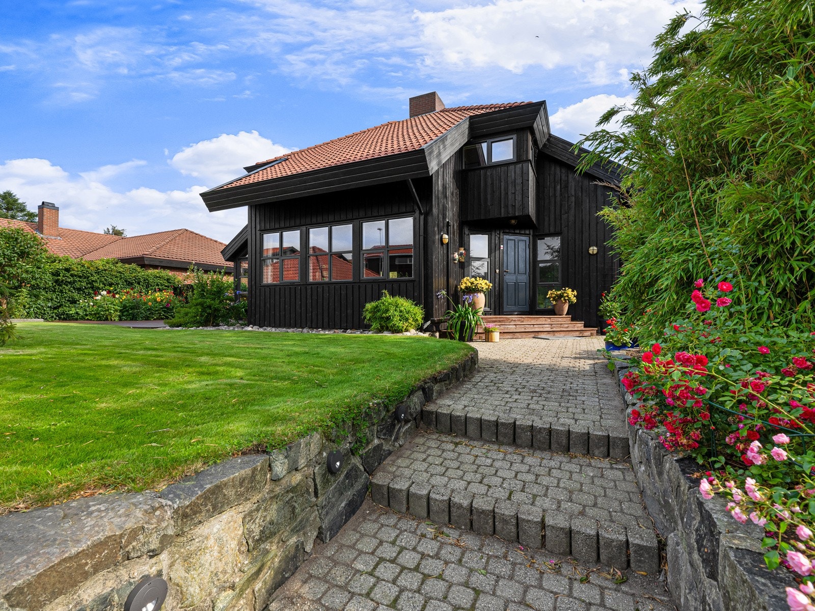 Tomten er pent opparbeidet med belegningsstein på gårdsplassen og opp til inngangspartiet. Galleribilde