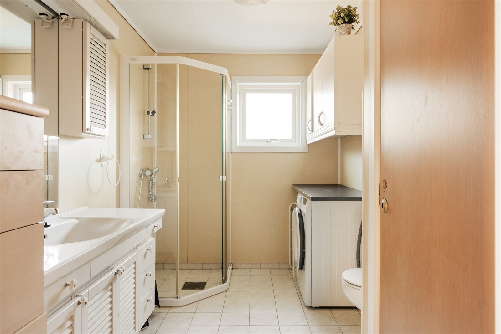 Badet har fliser i dusjsonen, baderomsplater på veggene og malte plater noe som gir et stilrent og helhetlig uttrykk Galleribilde