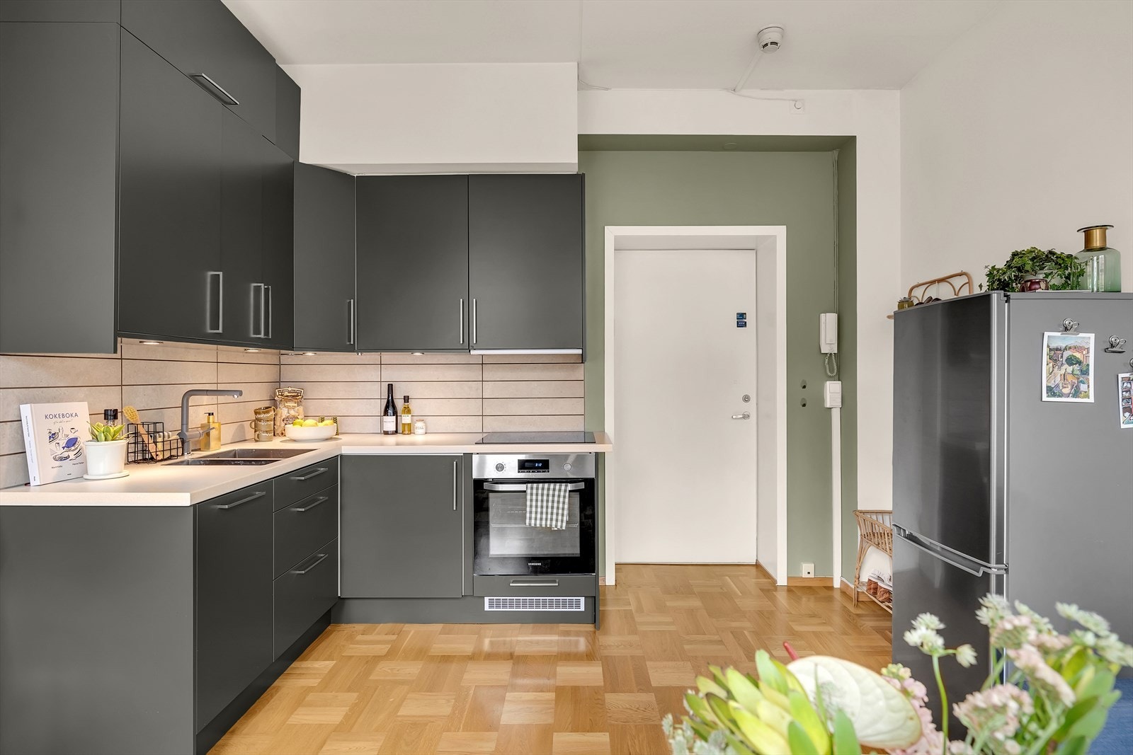 Innbydende kjøkkeninnredning fra 2018 med slette fronter, benkeplate i laminat og nedfelt rund oppvaskkum i rustfritt stål. Galleribilde