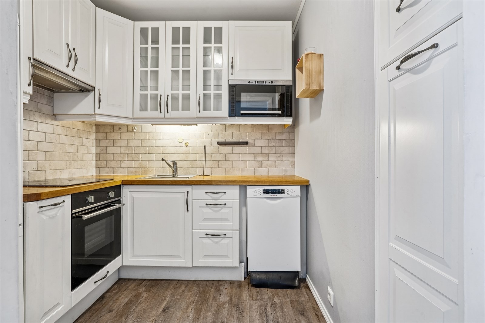 Kjøkkeninnredning med profilerte fronter og takhøye overskap. Galleribilde