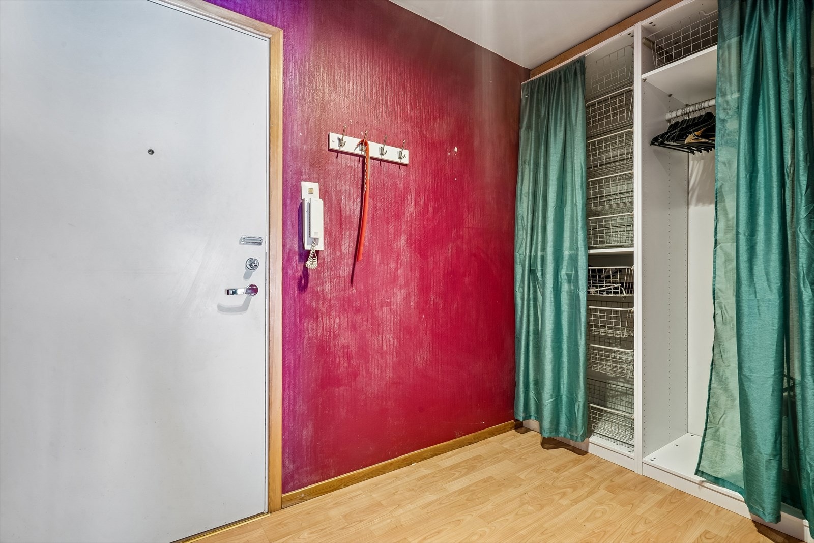 Velkommen inn! Porttelefon i gangen til felles inngangsdør. Garderobeskap med forheng i gangen. Galleribilde