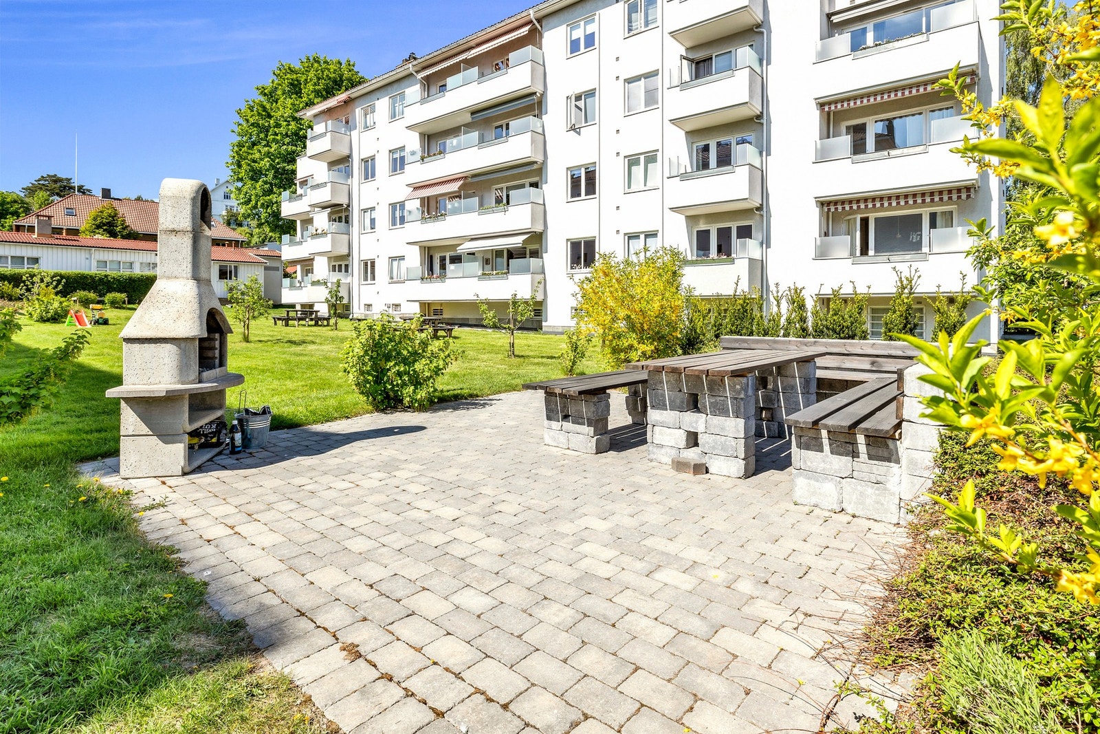 Fellesområder sommerstid. Borettslaget har flotte parkmessige fellesområder med gressplen, sittegrupper og grill Galleribilde