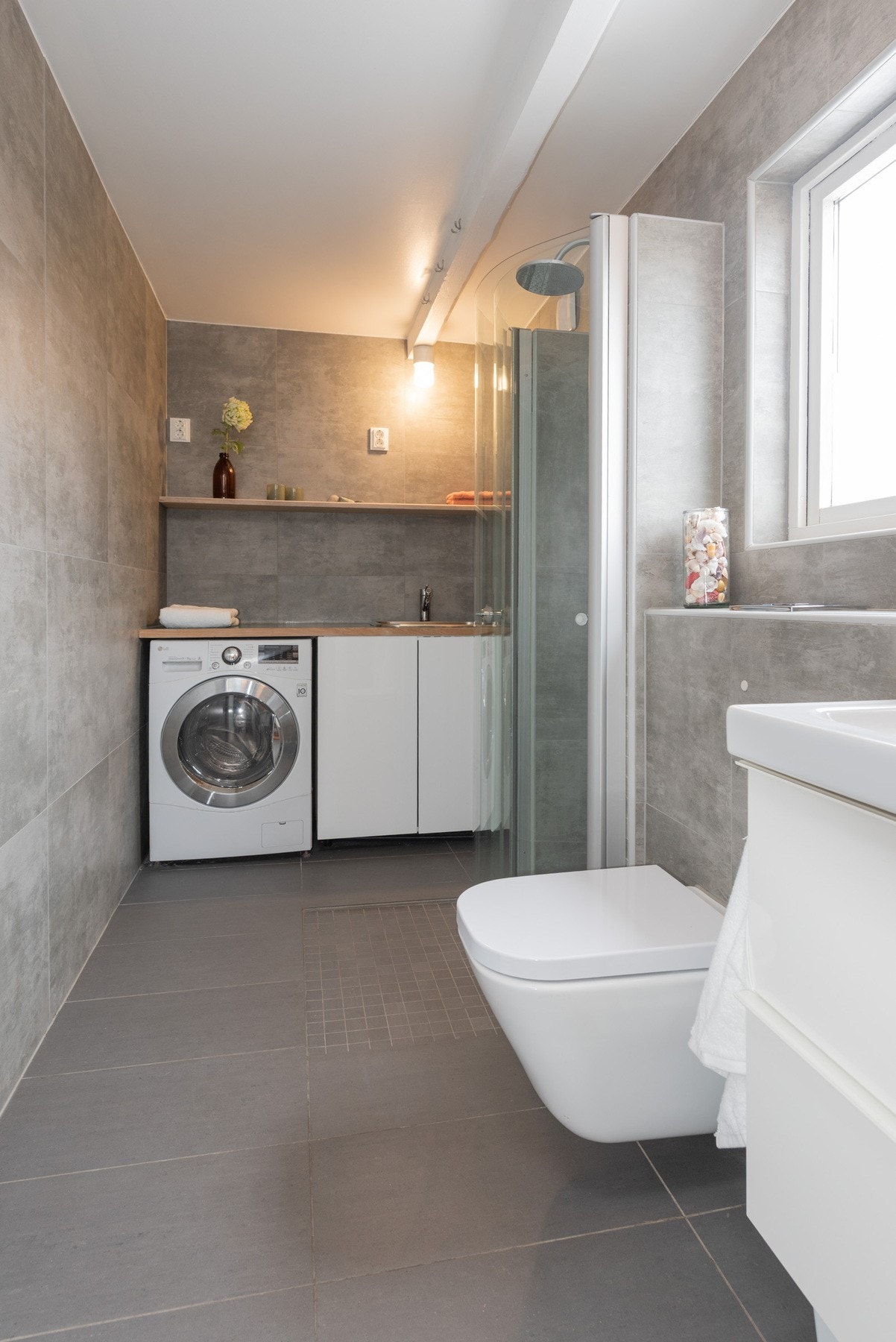 Badet har også sin egen vaskesone. Her er det opplegg for vaskemaskin, og en praktisk innredning med utslagsvask. Galleribilde