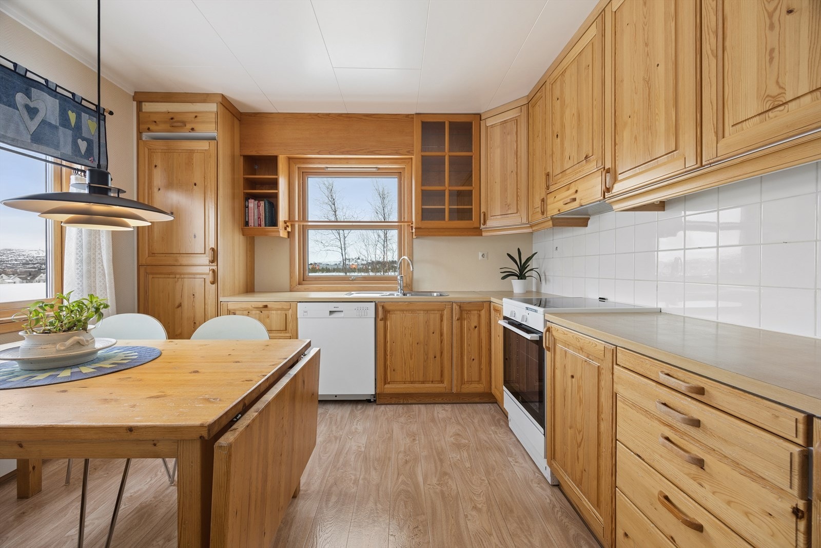 Kjøkkenet har en praktisk innredning med profilerte trefronter og takhøye overskap. Galleribilde