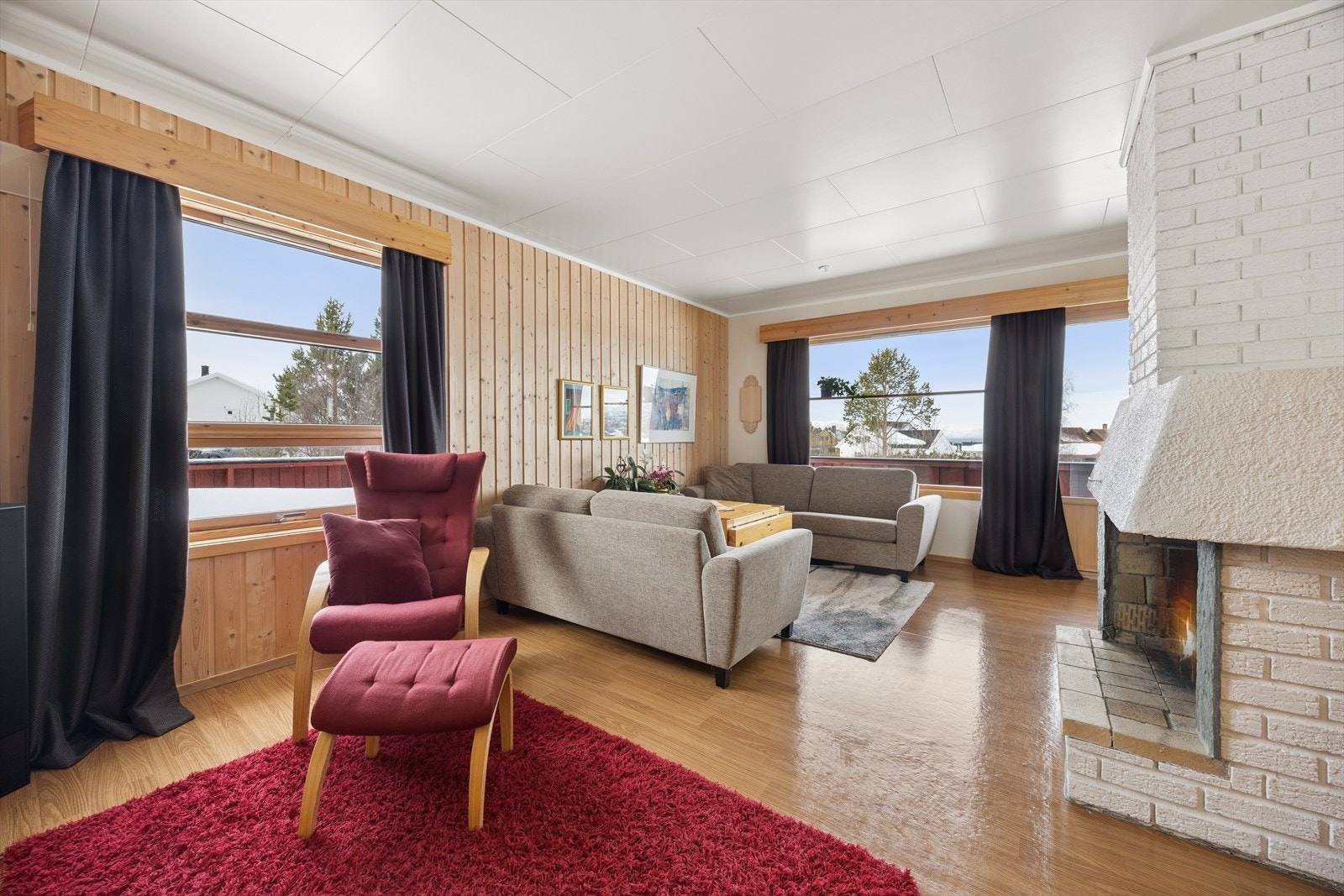 Stuen har store vindusflater som slipper inn godt med naturlig lys og gir rommet en lys og luftig følelse. Galleribilde