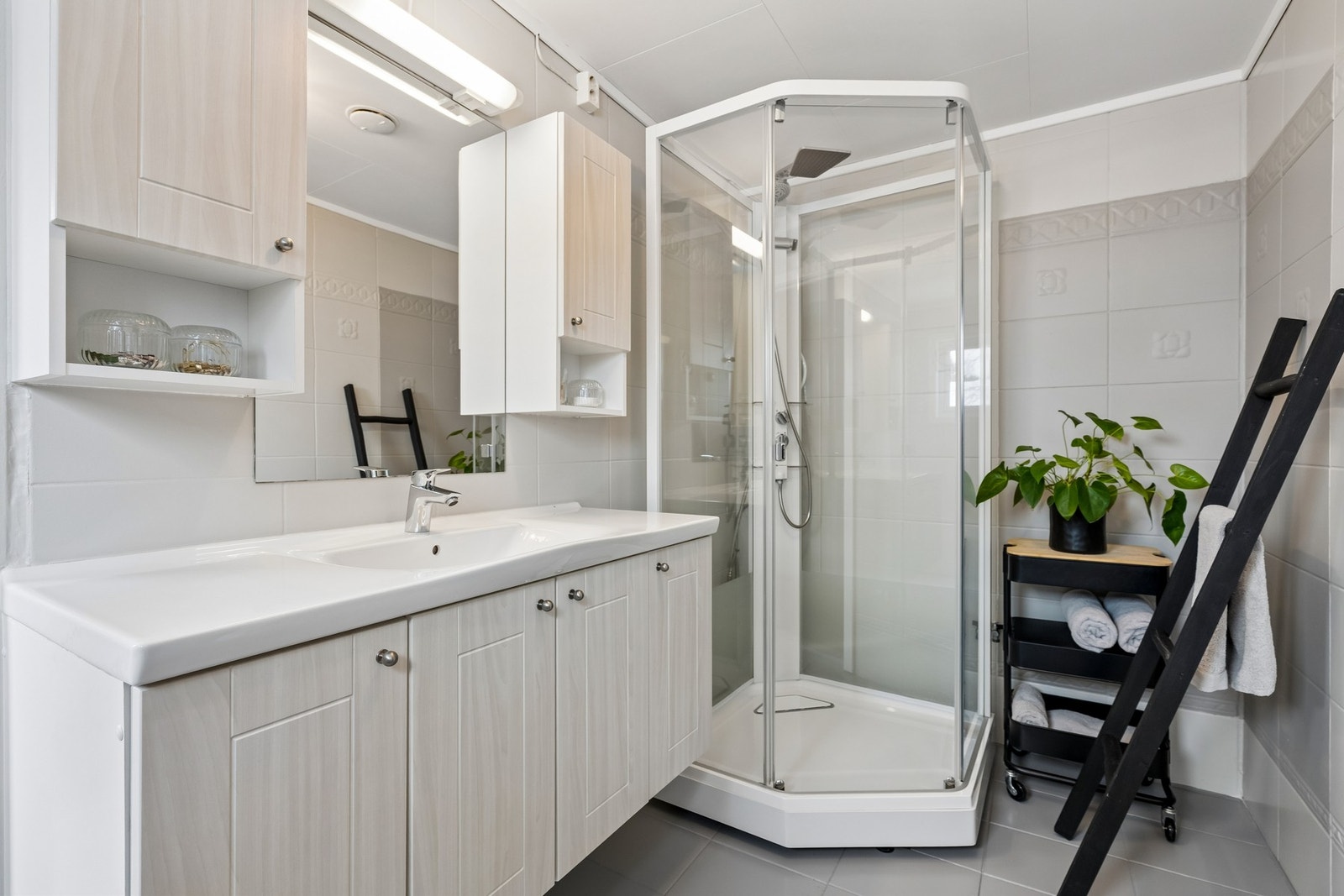 Flislagt bad med gulvvarme, dusjkabinett og lys innredning. Galleribilde