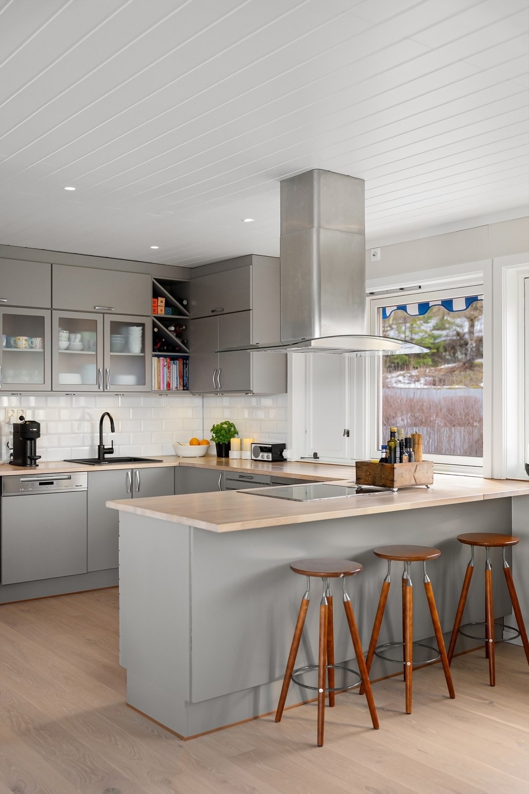 Kjøkkenet er innredet med malte, glatte fronter og heltre benkeplate. Galleribilde