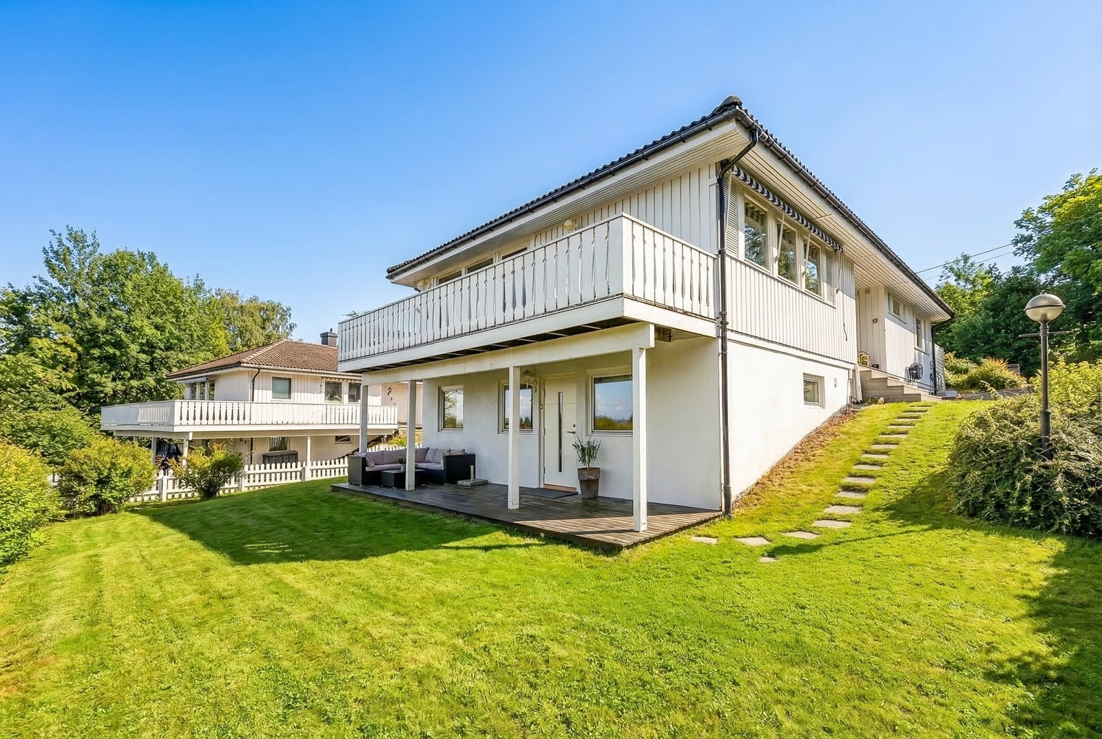 Pent opparbeidettomt med nylig plantet syrinhekk mot naboen. (Redigert fra vinter til sommer) Galleribilde