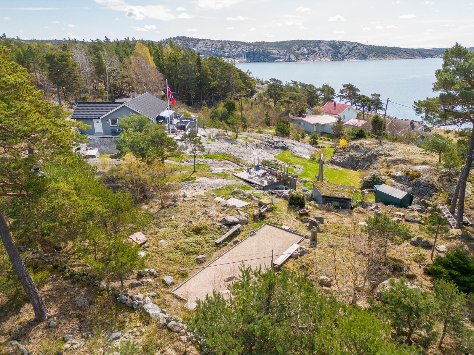 Stor tomt på drøye 2 mål med gressplen, Boulebane, svaberg og terrasser/plattinger Galleribilde